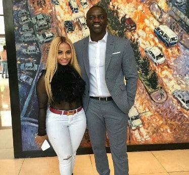 Akon wearing grey suit and Tomeka wearing white jeans.